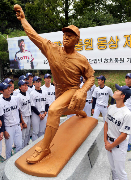 지난 14일 부산 사직야구장에서 열린 ‘무쇠팔 투수’ 최동원 동상 제막식에 참가한 경남고 후배 야구부원들이 동상을 둘러보고 있다.  부산 연합뉴스