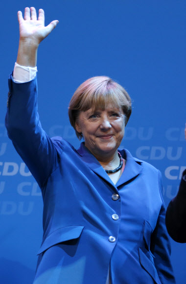 앙겔라 메르켈 독일 총리가 이끄는 기독교민주당(CDU)과 기독교사회당(CSU) 연합이 22일(현지시간) 실시된 총선에서 압승을 거둔 것으로 출구조사 결과 드러나 메르켈 총리의 3선이 사실상 확정적이다. 메르켈 총리가 이날 베를린의 당 본부에서 지지자들에게 손을 흔들고 있다. AP 연합뉴스