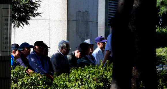 서울 종묘공원에서 노인들이 나무그늘에 앉아 이야기를 나누고 있다.  연합뉴스