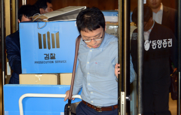 검찰이 사기성 회사채·기업어음(CP) 발행과 관련해 서울 중구 동양증권에서 12시간의 압수수색을 마친 후 15일 밤 11시쯤 수사관이 압수 물품을 차량으로 옮기고 있다. 