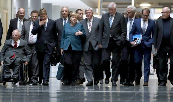 앙겔라 메르켈(가운데) 독일 총리가 15일(현지시간) 수도 베를린에서 연정을 구성하기로 한 기민당·기사당 연합과 녹색당의 3차 협상을 위해 이동하고 있다. 메르켈 총리가 이끄는 기민당은 최근 BMW로부터 69만 유로의 로비를 받았다는 의혹을 받고 있다. 베를린 AP 연합뉴스