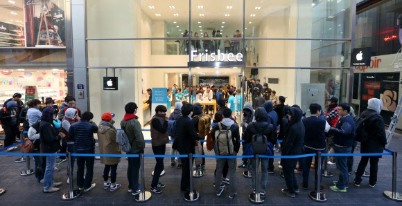 애플의 신제품 아이폰5S, 5C 출시일인 25일 오전 서울 중구 명동의 한 전자기기 매장 앞에 아이폰을 사려는 사람들이 줄을 서있다. 연합뉴스