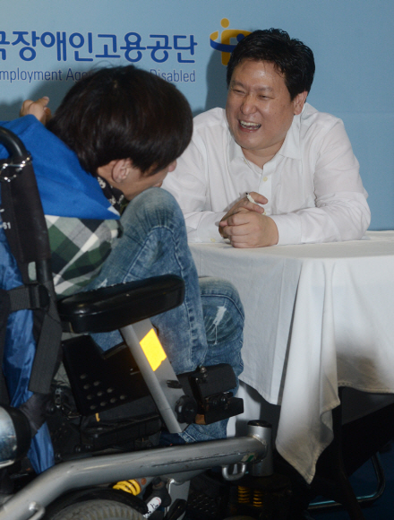 세계적 로봇 공학자 데니스 홍(오른쪽) 미국 버지니아공대 교수가 지난 1일 서울 서초구 양재동 aT센터에서 열린 강연회에서 사인을 받으러 온 장애인 관람객과 대화를 나누며 활짝 웃고 있다. 안주영 기자 jya@seoul.co.kr