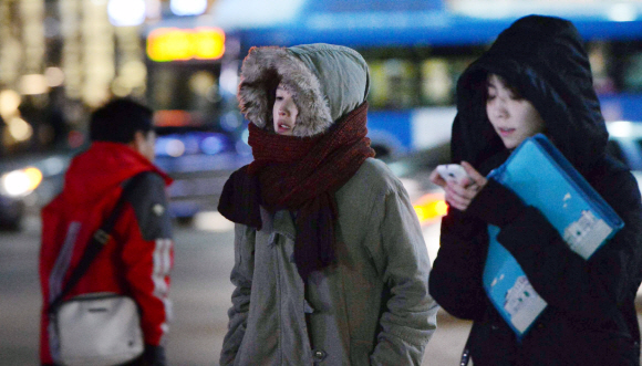 두꺼운 옷차림의 퇴근길 시민들이 차가워진 날씨에 몸을 웅크린 채 서울 광화문 거리를 걷고 있다.
