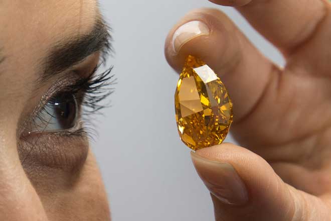 지난1일 크리스티 직원이 세계 최대로 추정되는 생생한 오렌지 빛깔의 다이아몬드를 기자들에게 선보이고 있다.AP/뉴시스