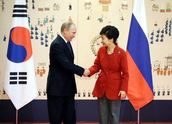 박근혜 대통령이 13일 청와대를 방문한 블라디미르 푸틴 러시아 대통령과 기념촬영에 앞서 악수하고 있다.  연합뉴스