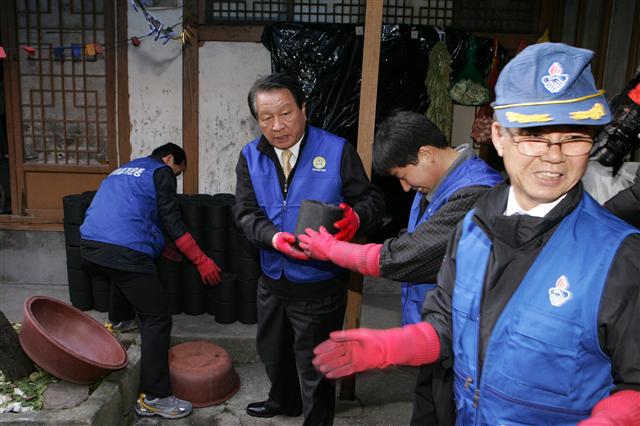 4선인 고재득(왼쪽에서 두 번째) 서울 성동구청장이 금호동 저소득 가구를 찾아가 바르게살기연합 회원들과 함께 연탄을 나르고 있다.