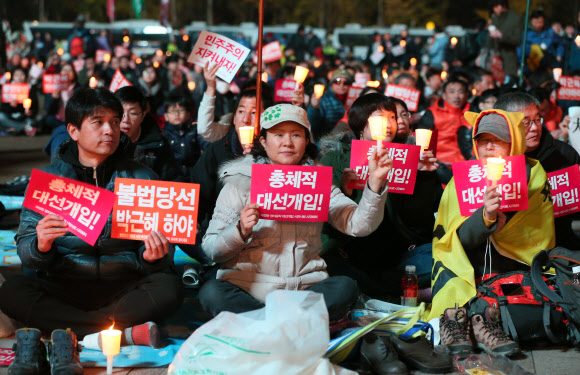 16일 오후 참여연대 등 시민단체로 구성된 시국회의가 서울광장에서 가진 20차 범국민촛불대회에서 참가자들이 촛불과 손팻말을 들고 공연을 지켜보고 있다.