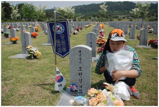 조시은양이 지난 5월 대전국립현충원으로 체험학습을 가 아버지 조천형 중사의 묘비 앞에 놓을 꽃다발을 들고 있다. 복수초등학교 제공