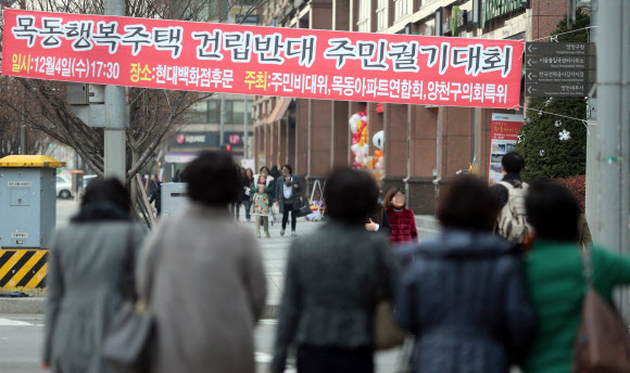 행복주택 궤도 전환…시행 1년도 안돼 대폭 손질 정부는 첫 시범사업부터 삐걱거리고 있는 행복주택 사업을 활성화하기 위해 사업의 방향을 대폭 전환했다. 공급물량을 6만가구 정도 축소하고 사업부지도 철도부지는 최소화하고 공공택지의 미매각 토지, 도시재생용지 등 동원이 쉬운 토지로 확대했다. 3일 서울 양천구 목동에서 시민이 목동 행복주택 건립반대 궐기대회를 알리는 현수막 앞을 지나고 있다.  연합뉴스