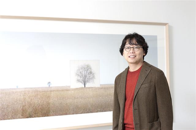 ‘나무 연작’ 작품 앞에서 미소 짓고 있는 이명호 작가. 갤러리현대 제공 