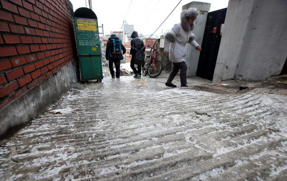 빙판길을 피해서 전국적으로 눈이 내린 11일 오후 서울 용산구 이태원동에서 시민이 조심스럽게 발걸음을 옮기고 있다.  연합뉴스