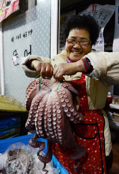 큼직한 ‘영주 문어’를 들고 있는 엄순희 할머니. 영동선 열차만 17년을 탄 번개시장 터줏대감이다.