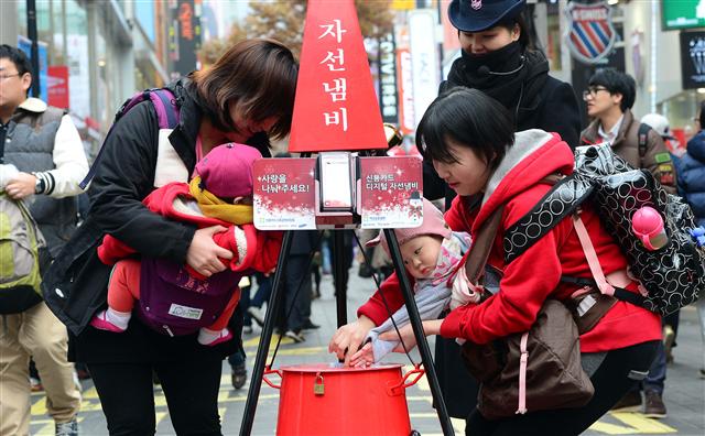 지난 2일부터 전국 모금운동에 돌입한 구세군 자선냄비에 시민들이 성금을 넣고 있다. 서울신문 포토라이브러리