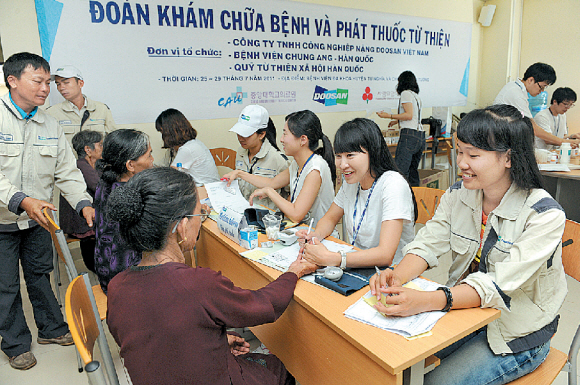 두산중공업의 베트남 현지법인 ‘두산비나’ 직원들이 베트남을 방문한 중앙대의료원 의료진과 함께 현지 캠프에서 진료검진 봉사활동을 하고 있다.  두산그룹 제공