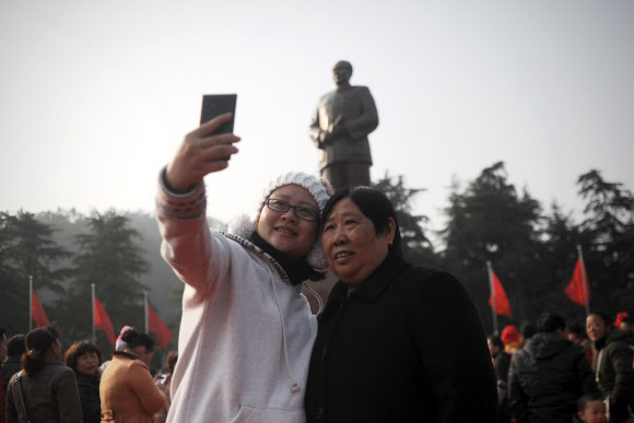 두 여성이 마오쩌둥 동상을 배경으로 기념촬영을 하고 있다. 사오산 AFP 연합뉴스