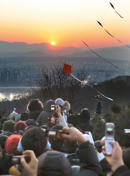 지난해 1월 1일 서울 광진구 광장동 아차산에서 시민들이 떠오르는 해를 놓치지 않으려 휴대전화, 디지털카메라에 담고 있다.