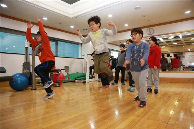 겨울방학을 맞아 비만교실에 참여한 초등학생들이 14일 서울 서초구 서초동 양재YMCA 체육관에서 구호에 맞춰 제자리 뛰기를 하며 근력을 키우고 있다. 서초구청 제공