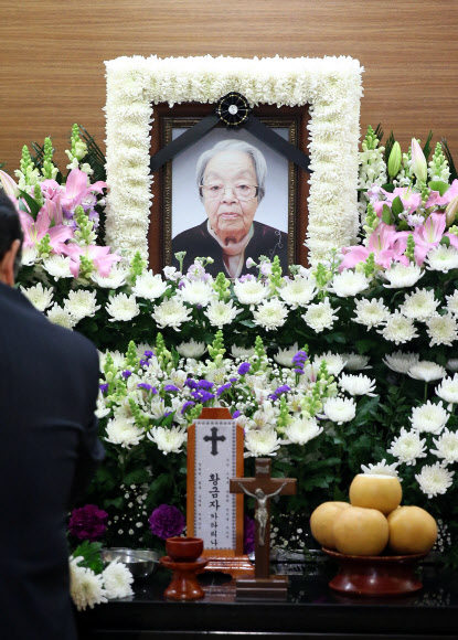 26일 오후 서울 목동 이대병원 장례식장에 마련된 일본군 위안부 피해자 황금자 할머니의 빈소를 찾은 한 조문객이 분향 및 헌화를 하고 있다.  연합뉴스