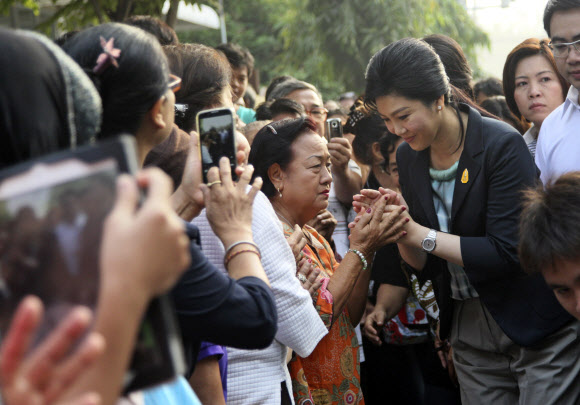 태국 정부가 조기 총선을 강행한 2일 방콕의 한 투표소로 투표를 하러 나온 잉락 친나왓 총리가 지지자들과 인사를 나누고 있다. 방콕 AP 연합뉴스