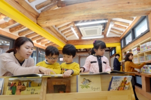 서까래 아래서 책에 푹 빠진 아이들