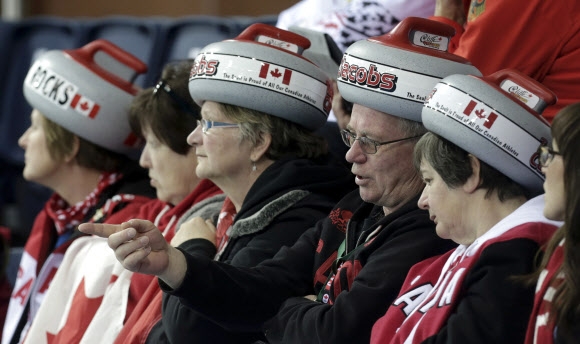 컬링 스톤을 닮은 모자를 쓴 캐나다 응원단이 12일(현지시간) 아이스 큐브 컬링 센터에서 열린 캐나다 대 러시아의 소치동계올림픽 여자부 예선 경기서 자국팀을 응원하고 있다. 로이터/뉴스1