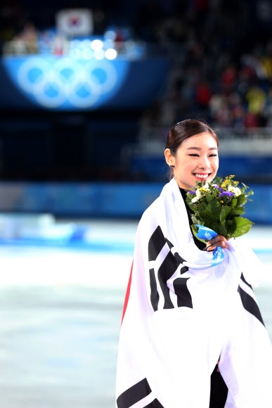 제22회 러시아 소치 동계올림픽에 출전한 ‘피겨 여왕’ 김연아가 21일 오전(한국시간) 소치 아이스버그 스케이팅 팰리스에서 열린 여자 피겨스케이팅 싱글 에서 은메달을 차지한 뒤 태극기를 두른 채 링크를 돌고 있다.  연합뉴스