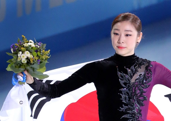 피겨여왕 김연아가 21일 오전 (한국시간) 러시아 소치 아이스버그 스케이팅 팰리스에서 열린 2014 소치 동계올림픽 피겨스케이팅 여자 싱글에서 러시아 아델리나 소트니코바에 이어 은메달을 획득했다. 김연아가 플라워세리머니를 마친 뒤 태극기를 몸에 감고 관중에게 인사하고 있다.  연합뉴스