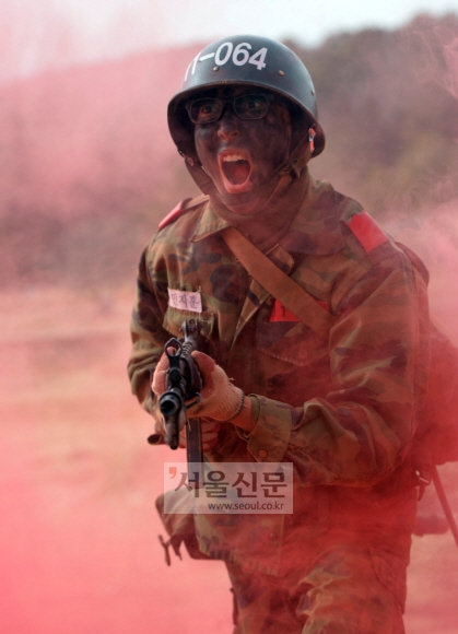 지난 19일 육군훈련소 종합각개전투 훈련장에서 안면 위장을 한 훈련병이 함성을 지르며 앞으로 뛰어나가고 있다. 논산 박지환 기자 popocar@seoul.co.kr