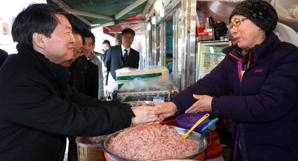 3월 창당 예정인 새정치연합의 안철수 무소속 의원이 21일 경기 수원시 지동시장을 방문해 상인과 악수를 하고 있다. 연합뉴스