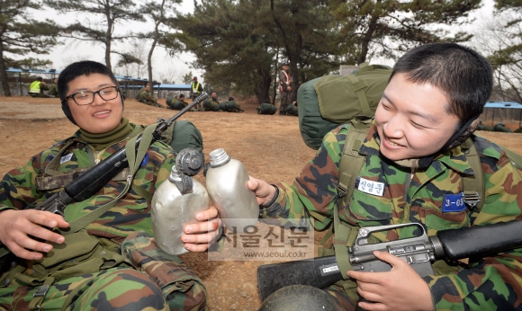 충남 논산시 육군훈련소에 입소해 행군 훈련을 받고 있는 훈련병들이 지난 17일 훈련 도중 주어진 10분간의 짧은 휴식시간에 수통으로 완주를 다짐하는 건배를 하고 있다. 입소 5주차 훈련병들은 20㎏의 완전 군장을 메고 20㎞ 행군 훈련을 받는다. 논산 박지환 기자 popocar@seoul.co.kr