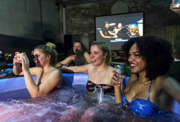 6일(현지시간) 네덜란드 암스테르담의 욕조 영화클럽에서 영화팬들이 뜨거운 물을 받아 놓고 목욕을 즐기면서 영화를 보고 있다.  로이터/뉴스1