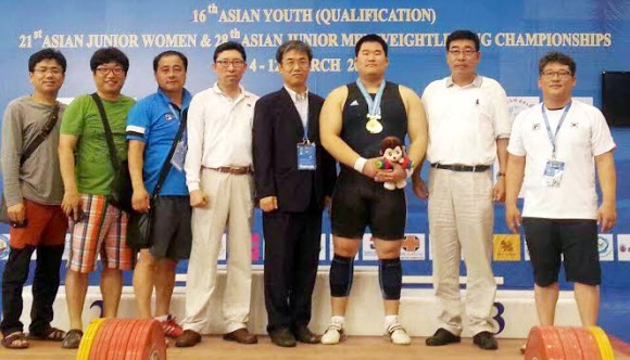이양재(오른쪽에서 세 번째)가 12일 태국 방센에서 열린 아시아 남자 주니어역도선수권 최중량급에서 합계 우승을 차지한 뒤 기념촬영을 하고 있다. 대한역도연맹 제공