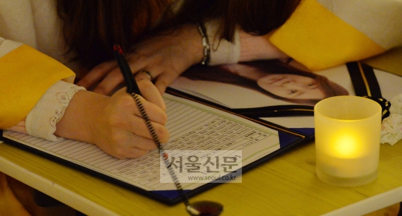 프로그램에 참여한 한 여성이 자신의 영정 사진 옆에 놓인 유언장을 써 내려가고 있다.  손형준 기자 boltagoo@seoul.co.kr