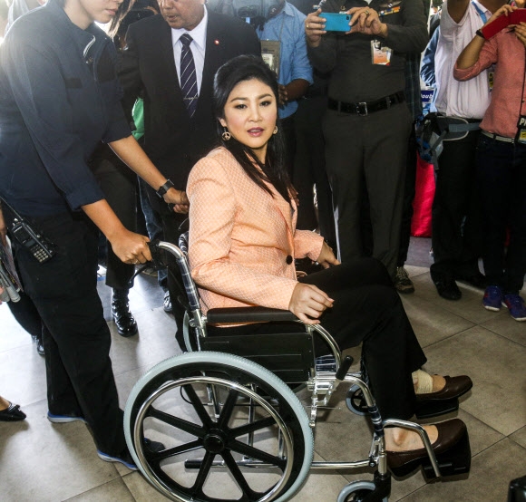 잉락 친나왓 태국 총리가 18일(현지시간) 나코른 파톰 주의 경찰학교에 휠체어를 타고 도착하고 있다. 태국정부는 시위대 감소로 인해 치안상황이 개선됨에 따라, 반정부시위를 억제하기 위해 시행했던 방콕과 주변 주에서의 비상사태를 해제할 예정이다. (로이터/뉴스1) 