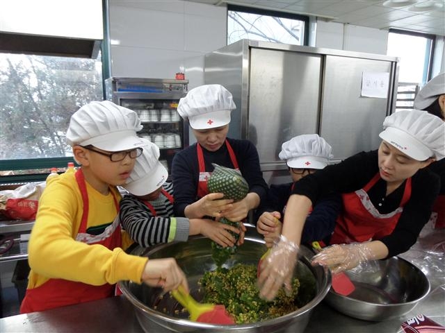 지난달 18일 서울 동대문구 신설동 옛 적십자봉사관에서 열린 ‘이야기 빵’ 만들기 행사에 참가한 가족 자원봉사자들이 어려운 이웃에게 나눠 줄 빵을 만들고 있다.  동대문구 제공