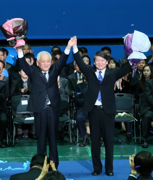 김한길(왼쪽)·안철수 공동대표가 26일 서울 잠실 올림픽공원 올림픽홀에서 열린 새정치민주연합 중앙당 창당대회에서 축하꽃다발을 들고 인사하고 있다.   연합뉴스