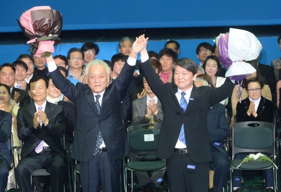 26일 서울 송파구 올림픽공원 올림픽홀에서 열린 새정치민주연합 중앙당 창당대회에서 공동대표로 선출된 김한길(왼쪽)·안철수(오른쪽) 공동창당준비위원장이 당원들의 환호에 답례하고 있다. 안주영 기자 jya@seoul.co.kr