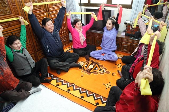 조길형(왼쪽에서 두 번째) 영등포구청장이 독거노인 두레 공동체 ‘함께 살이 사업’ 프로그램이 진행 중인 가정에서 함께 줄체조를 하고 있다. 영등포구 제공