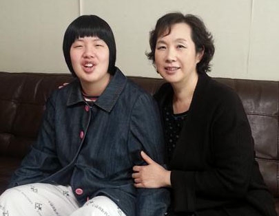 최근 발목을 다친 자폐성 장애 1급 양지선(왼쪽)씨가 1일 서울 서초구 방배동 자택에서 어머니 김혜연씨와 함께 나란히 소파에 앉아 천진난만하게 웃고 있다.