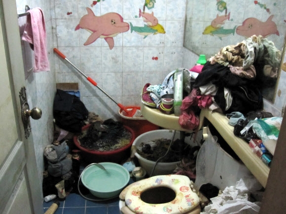 초·중·고생 4남매가 살았던 쓰레기통과 구분이 안 되는 화장실. 빨래와 용변을 본 뒤 사용한 휴지가 함께 뒤섞여 있다. 인천지방경찰청 제공