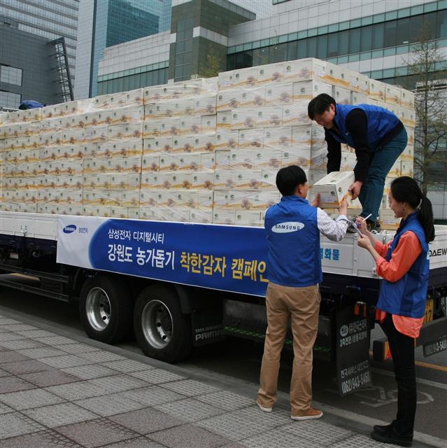 삼성전자가 감자 풍작과 소비 저하로 어려움을 겪는 강원도 감자 농가를 돕기 위해 ‘착한감자’ 캠페인을 펼치고 있는 가운데 17일 경기 수원시 매탄동 디지털시티에서 직원들이 구매한 감자를 옮기고 있다.  삼성전자 제공