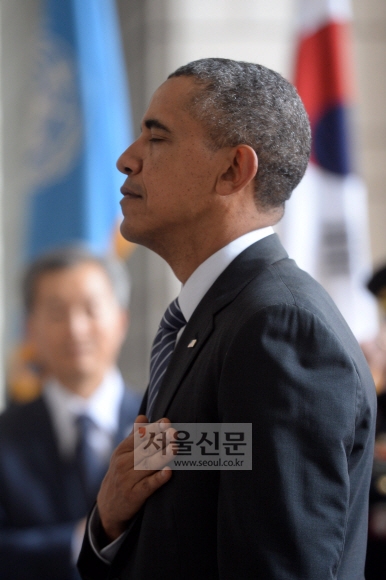 25일 방한한 버락 오바마 미국대통령이 서울 용산구 전쟁기념관을 찾아 UN참전국 전사자 명비에 헌화한 후 가슴에 손을 얹고 있다. 사진공동취재단