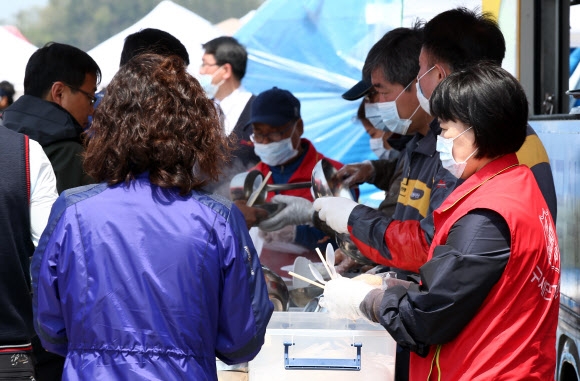 지난 21일 전남 진도군 팽목항에서 구세군자선냄비본부 자원봉사자들이 급식봉사를 하고 있다. 연합뉴스 *이 사진은 기사의 내용과 상관없는 성실한 봉사자들을 담고 있습니다.