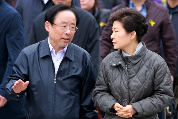박근혜 대통령이 세월호 침몰 사고 19일째인 4일 전남 진도군 임회면 팽목항에서 이주영 해양수산부 장관과 이야기를 나누며 실종자 가족과 면담을 하기 위해 이동하고 있다.  연합뉴스