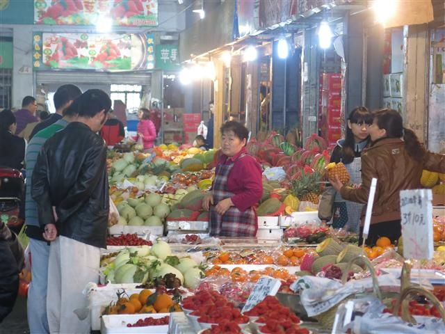 중국 상하이에 있는 ‘8번교 과일·채소 도매시장’에서 지난달 19일 중국 소비자들이 과일을 사기 위해 상인과 대화를 나누고 있다.