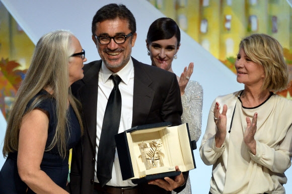 24일(현지시간) 폐막한 제67회 칸영화제에서 터키의 누리 빌제 세일란(왼쪽에서 두 번째) 감독이 영화 ‘윈터 슬립’으로 황금종려상을 받고 활짝 웃고 있다. 그는 “이 상을 (터키 반정부 시위 때) 목숨을 잃은 이들을 포함해 모든 터키 젊은이들에게 바치고 싶다”고 밝혔다. 칸 AFP 연합뉴스