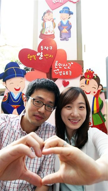 혼인 신고를 위해 동작구청을 찾은 신혼부부가 구청에 마련된 포토존을 배경으로 ‘인증샷’을 찍고 있다. 동작구 제공