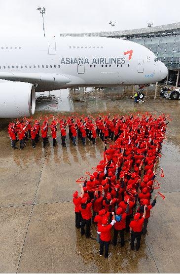 26일 프랑스 툴루즈 에어버스 항공기 인도센터에서 열린 아시아나항공의 A380 1호기 인수식에서 에어버스 직원들이 아시아나항공의 상징인 윙(Wing) 로고를 형상화하고 있다. 아시아나항공 제공