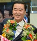 영남에서 재선에 성공한 새정치민주연합 김맹곤 경남 김해시장이 5일 꽃다발을 목에 걸고 활짝 웃고 있다. 선거사무소 제공